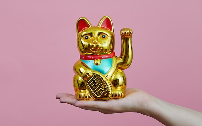 写真：手の上に金色の招き猫が乗っています。
