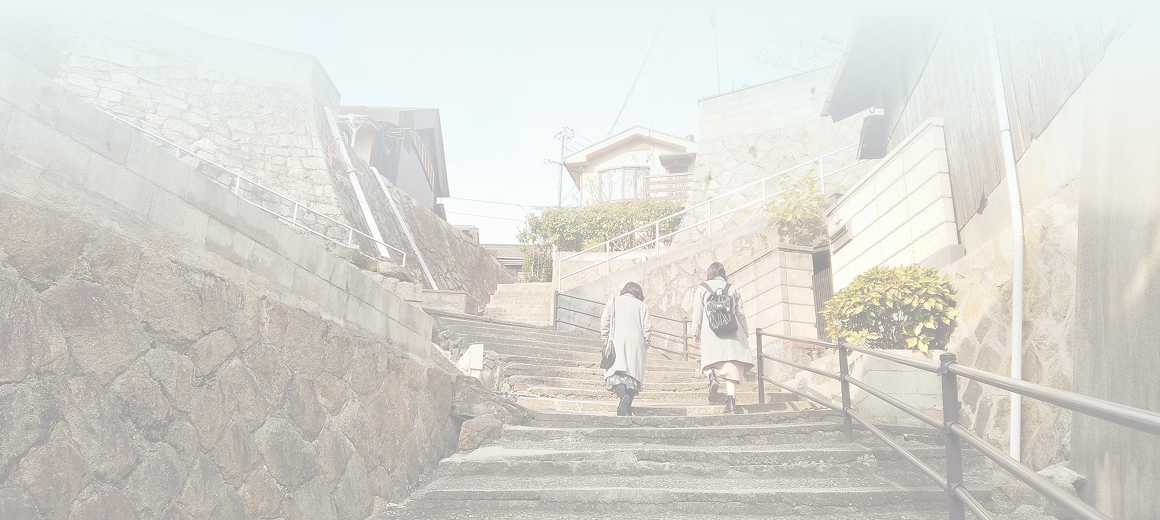 背景画像：女性2人が階段を登っています