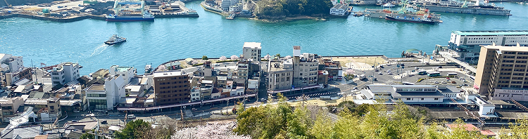 背景画像：尾道を上から見下ろした風景。海や街並みが写っています。